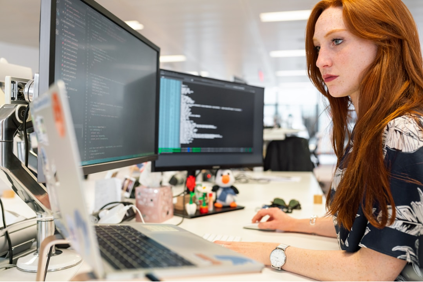 A woman in an office researching customer journey orchestration on her computer